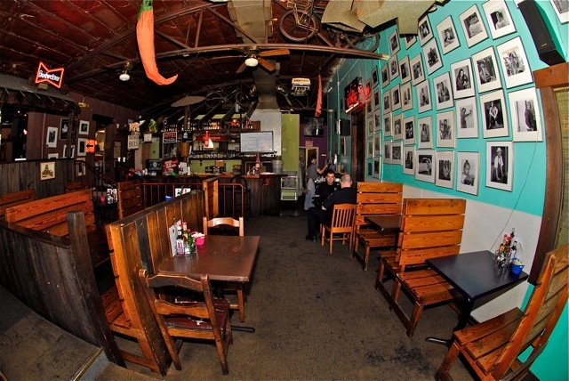 The dining room: wooden booths, teal walls, framed portraits and a chili pepper hanging from the ceiling.
