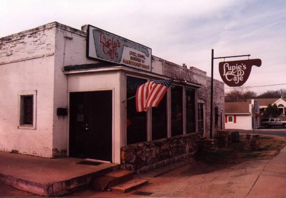 The Lupie's Cafe storefront in an early photograph, with the hand painted sign and a flag over the door.